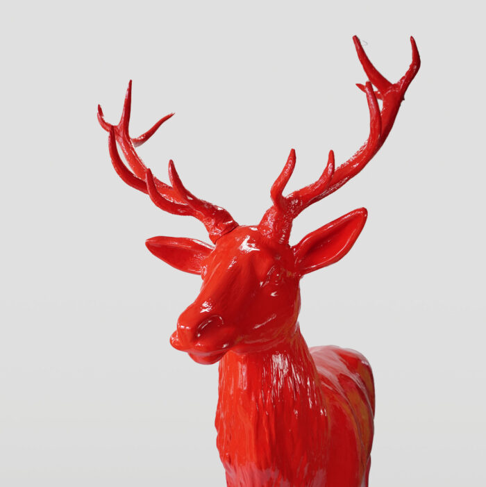 Bright red deer statue with prominent antlers against a plain white background.