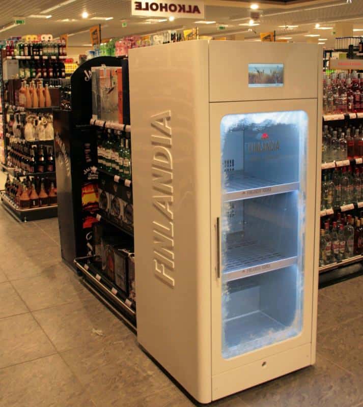 oryg_064490685_1129949550544944_1465385417682452480_o A large, white Finlandia-branded freezer in a liquor store aisle.