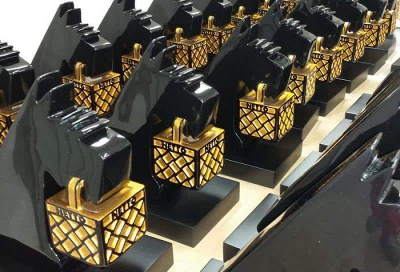 oryg_064490685_1129949550544944_1465385417682452480_o Rows of black dog-shaped statues holding gold latticed boxes with the word "HALO" on them.