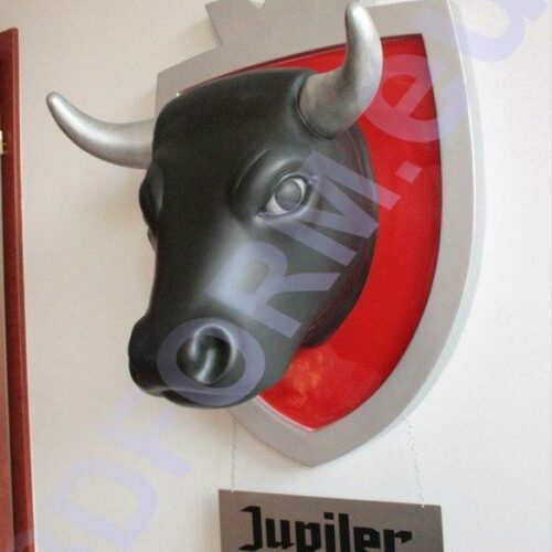 3D bull head with silver horns on a red shield, with a sign reading