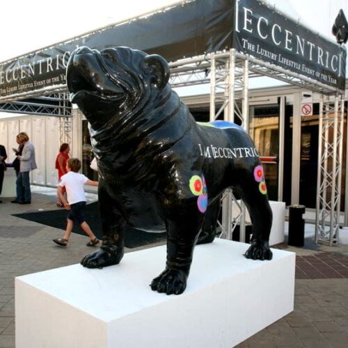 Black bulldog statue with colorful flowers painted on its sides and the text