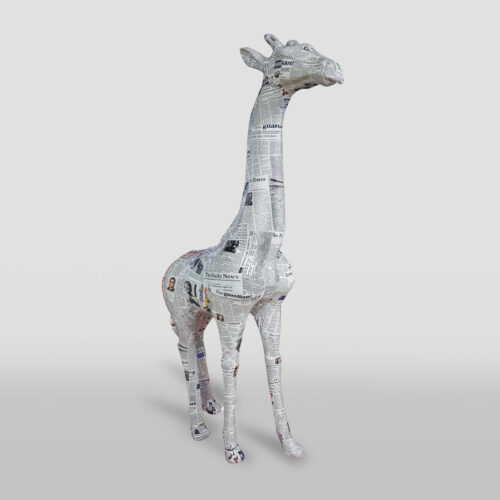 A giraffe sculpture covered entirely in newspaper clippings set against a plain, light background.