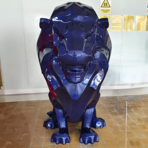A large, shiny blue statue of a lion positioned indoors on a tiled floor.