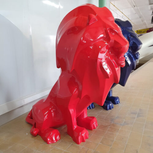 Red and blue glossy lion statues in a room with a tiled floor.