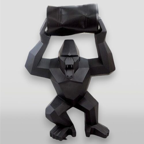 Sculpture of a geometric black gorilla holding a barrel overhead.