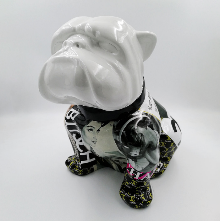 Ceramic bulldog figurine with a white head and body covered in black and white vintage magazine images and designer logos.