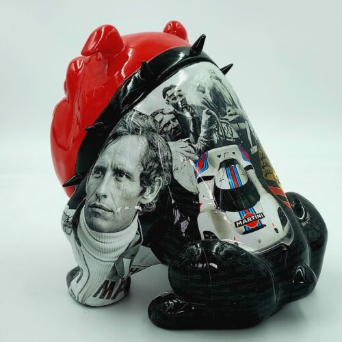 Red and black figurine with spiked details, featuring black and white photographs of a man and a racing car.