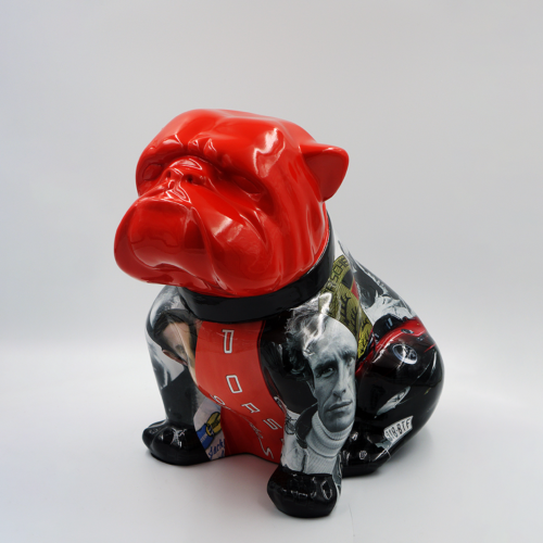 Statue of a bulldog with a glossy red face and a black body decorated with various graphic images and text.