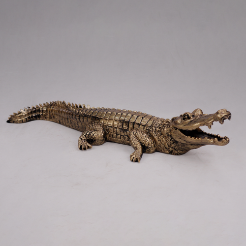 Bronze crocodile sculpture with mouth open, positioned on a white background.