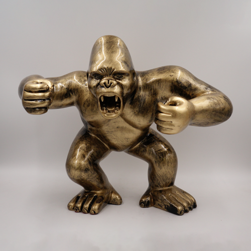 Bronze statue of a gorilla in an aggressive stance with fists clenched and mouth open.