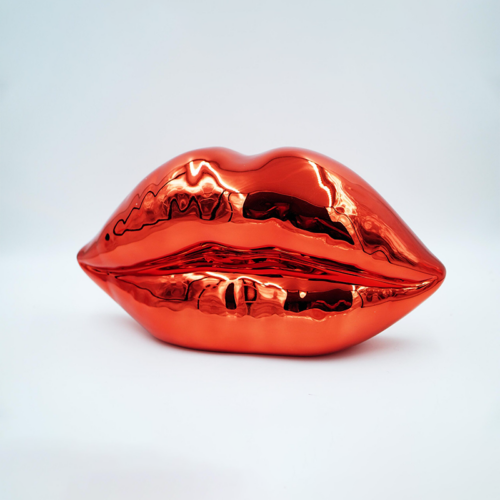 Sculpture of metallic red lips on a plain white background.