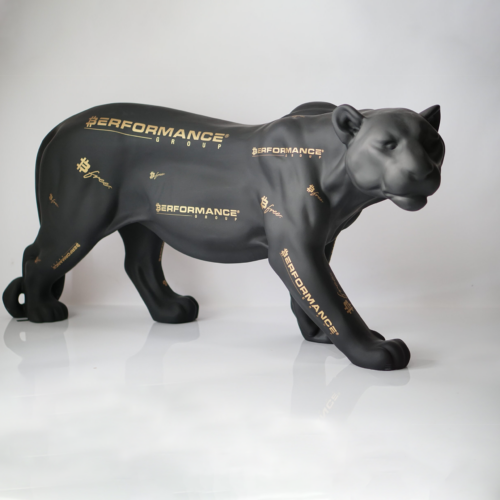 A matte black panther sculpture with gold text and logos, including the word “PERFORMANCE,
