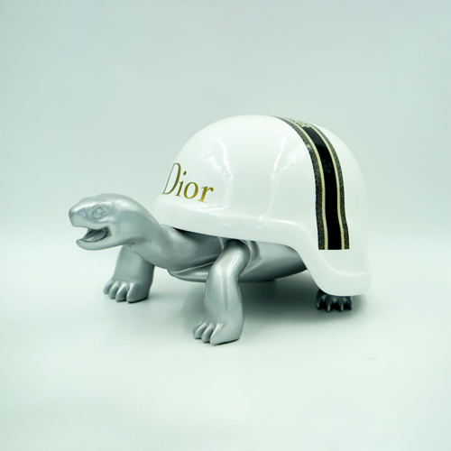 Silver turtle figurine wearing a white shell with