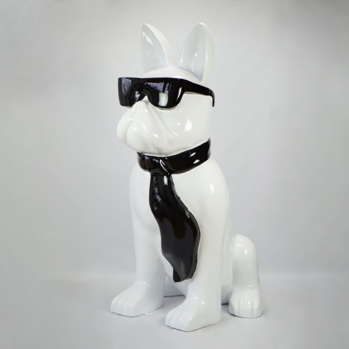 A white ceramic statue of a dog wearing black sunglasses and a black tie.