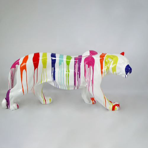 Sculpture of a white tiger painted with dripping rainbow colors.