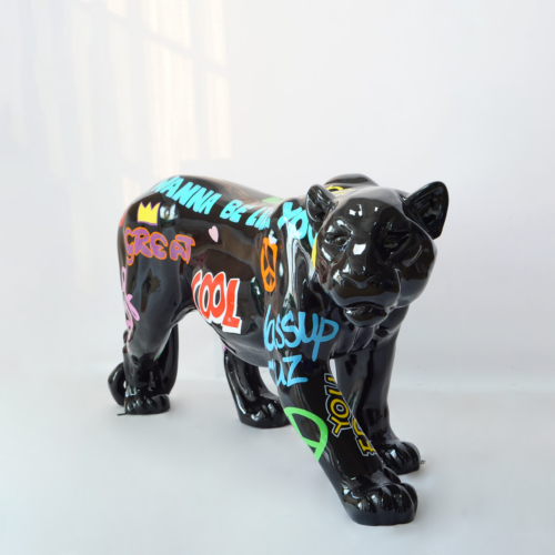 Black ceramic sculpture of a stylized cat with colorful graffiti-style text and symbols.