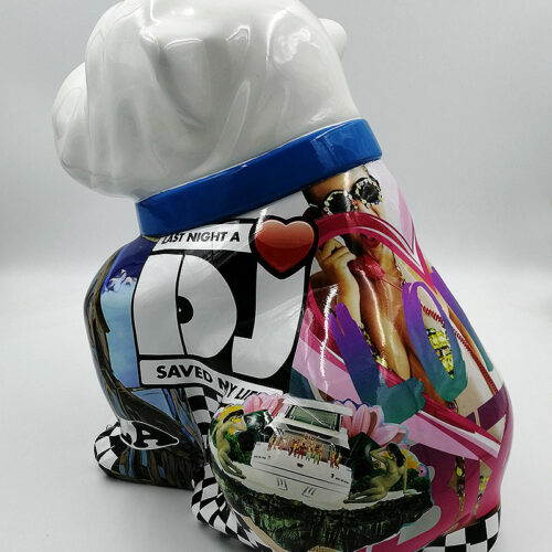 Sculpture of a bulldog with a white head and a colorful body featuring a collage of various images and text, including people, a yacht, and the phrase 
