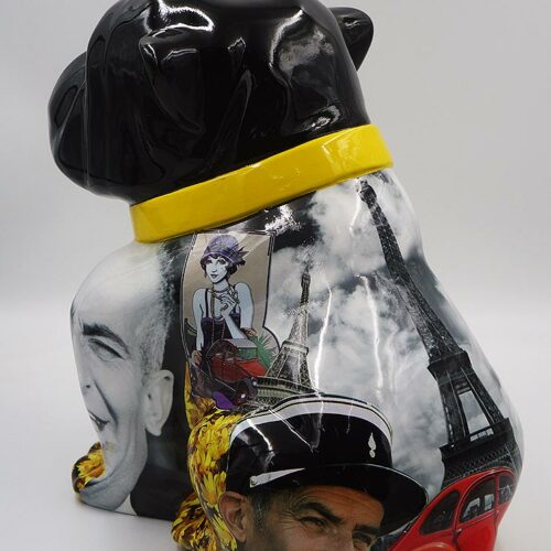 Black dog sculpture with a yellow collar featuring collage images, including a smiling man, the Eiffel Tower, a cartoon woman, and a red car.