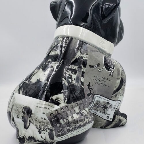 A black and white ceramic bulldog sculpture with collage images related to the history of football covering its body.