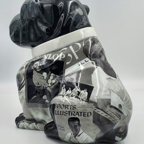 Black and white ceramic dog sculpture featuring various tennis-themed magazine cutouts.
