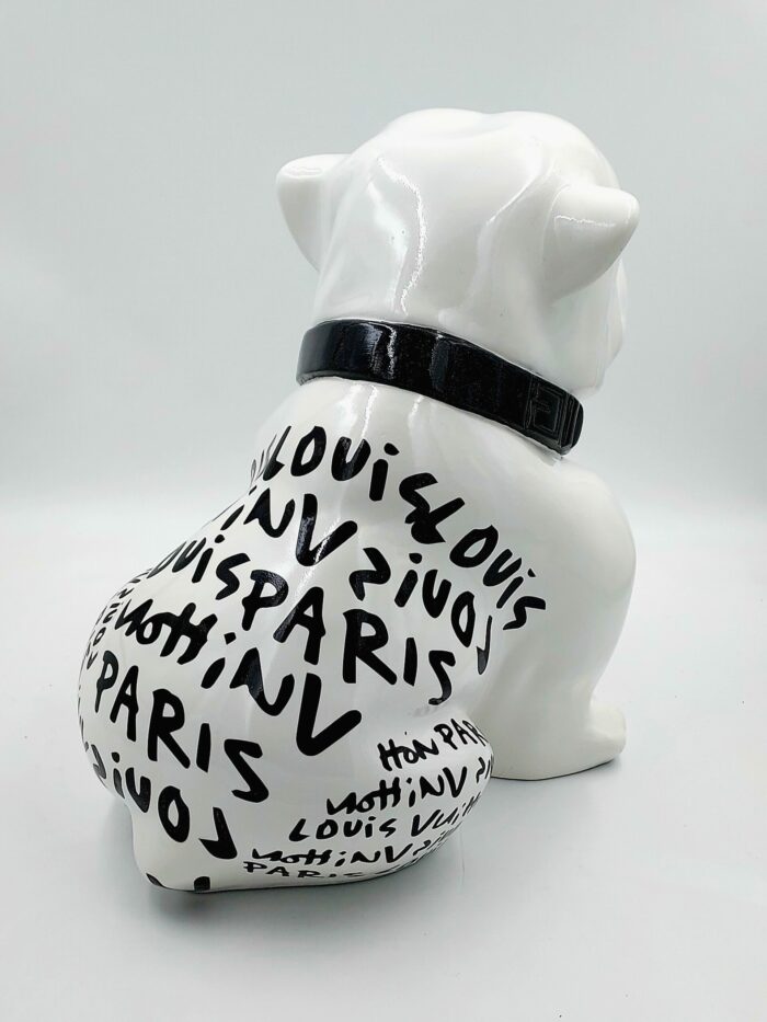 White bulldog sculpture with black text reading "Louis Vuitton Paris" multiple times and wearing a black collar.