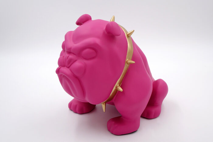 Pink bulldog sculpture with a gold spiked collar.