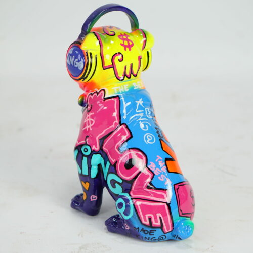 Colorful statue of a dog wearing headphones, covered in vibrant graffiti-style art and text.