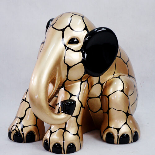 A gold elephant sculpture with black spots and black ears, featuring a smooth and shiny finish.
