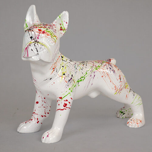 White dog statue with colorful paint splatters on its body and face.