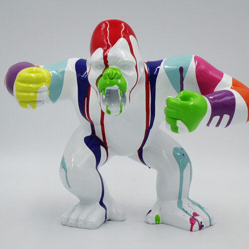 A colorful sculpture of a gorilla with paint drips in various hues, including green, red, blue, purple, yellow, and orange, standing against a plain background.
