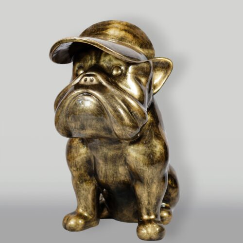 Bronze-colored sculpture of a sitting bulldog wearing a cap.