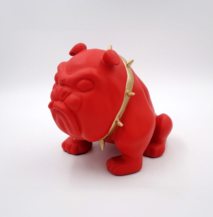 Red bulldog sculpture with a gold spiked collar.