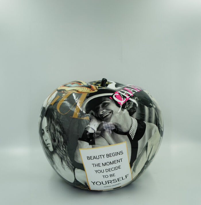 Large decorative sphere featuring black and white photographs of women and a quote, "Beauty begins the moment you decide to be yourself" - Coco Chanel.