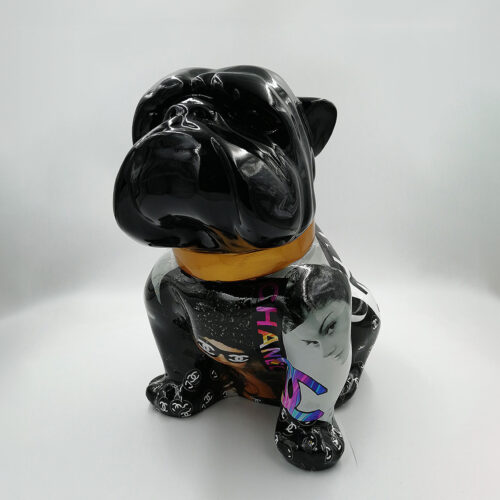 Black bulldog statue with collage artwork on its sides, featuring fashion brand logos, colorful text, and various images, wearing a gold collar, set against a white background.