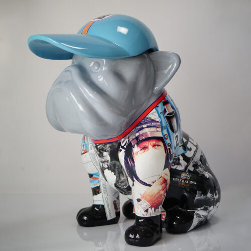 Rzeźba psa w czapce z daszkiem, ozdobiona kolorowymi obrazami i napisami.