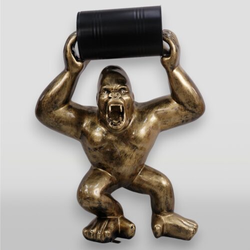 Bronze gorilla statue holding a black barrel overhead.