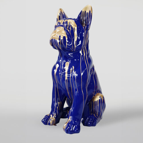 Statue of a sitting dog with a glossy blue surface and gold paint dripping from the top.