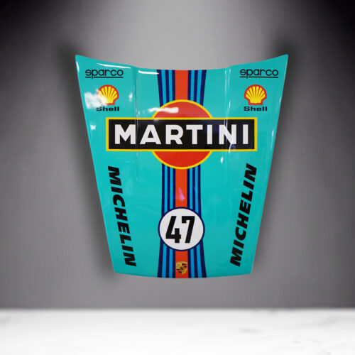 A car hood with Martini, Shell, Michelin, and Sparco logos, featuring the number 47 and Porsche emblem, on a light blue background with red, blue, and black stripes.