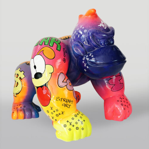 Colorful gorilla sculpture adorned with street art, including pop art graphics, dollar signs, and various brand logos.