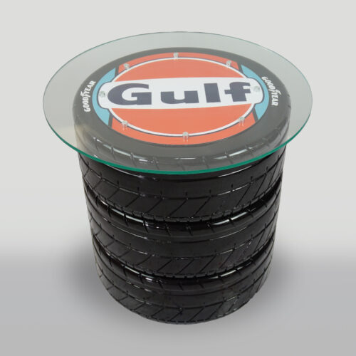Round glass-topped table with a base made of stacked racing tires branded with