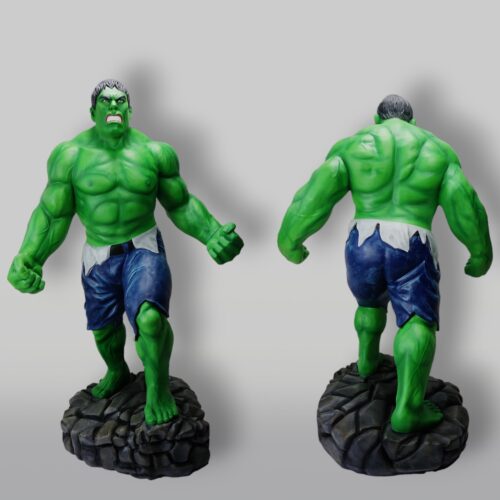 Two views of a green muscular statue with angry expression, wearing torn blue shorts and standing on a stone-like base.