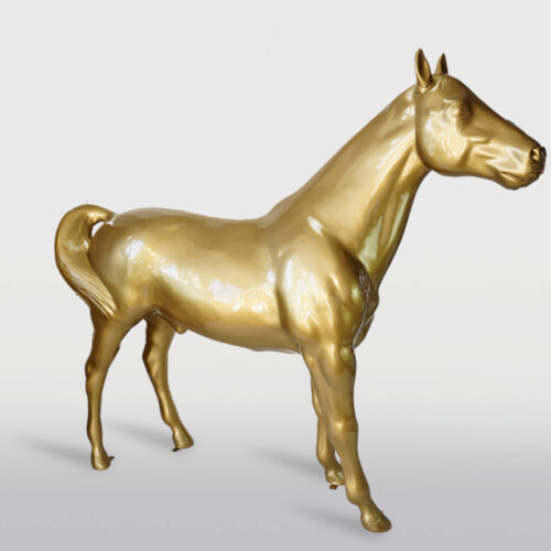 Golden horse statue against a white background.