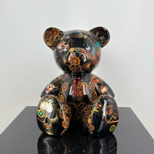 A black teddy bear sculpture with intricate steampunk designs, including gears, mechanical elements, and various colorful images such as a skull and human faces, displayed on a shiny, reflective surface.