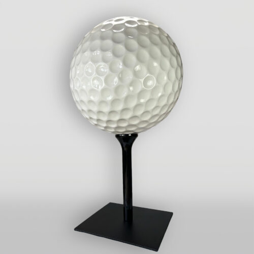 Giant golf ball sculpture on a sleek black stand.