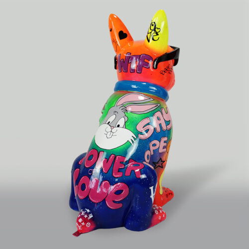 Graffiti-style painted ceramic dog sculpture with vibrant colors and words like