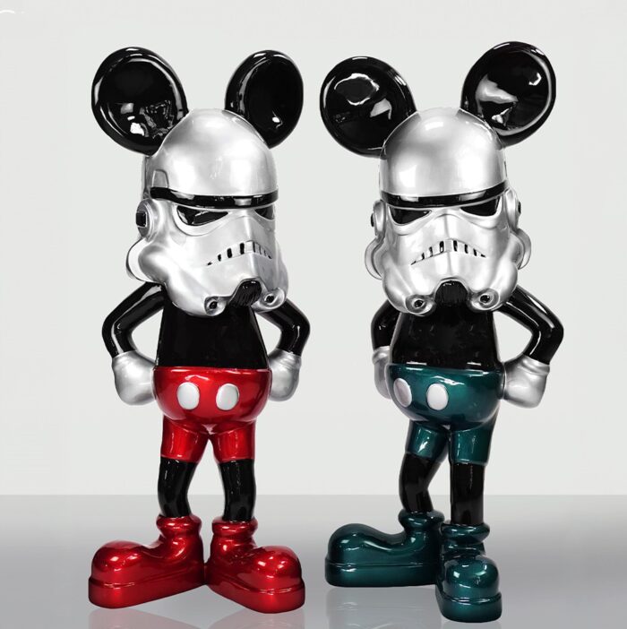 Two figurines combining elements of a stormtrooper helmet with Mickey Mouse attire, one in red and the other in green.