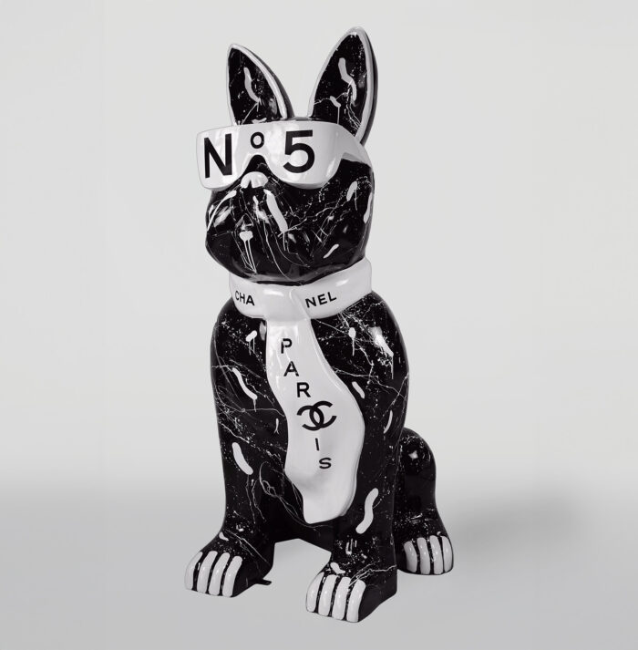 Statue of a black French bulldog wearing white sunglasses labeled "N° 5" and a white scarf with "CHANEL" and "PARIS" text and logo.