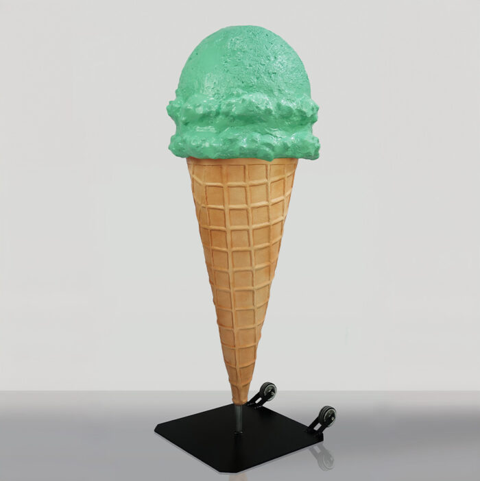 Large green ice cream cone sculpture on a black stand.