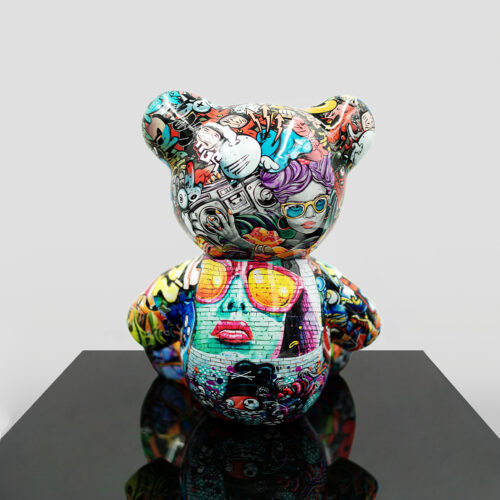 Artistic bear sculpture covered in vibrant, graffiti-style illustrations featuring various colorful characters and elements.