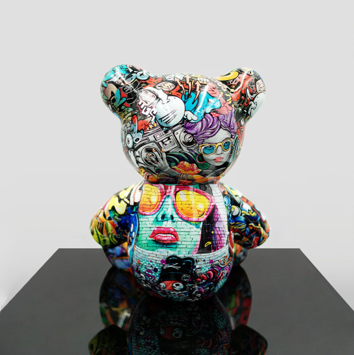 Artistic bear sculpture covered in vibrant, graffiti-style illustrations featuring various colorful characters and elements.